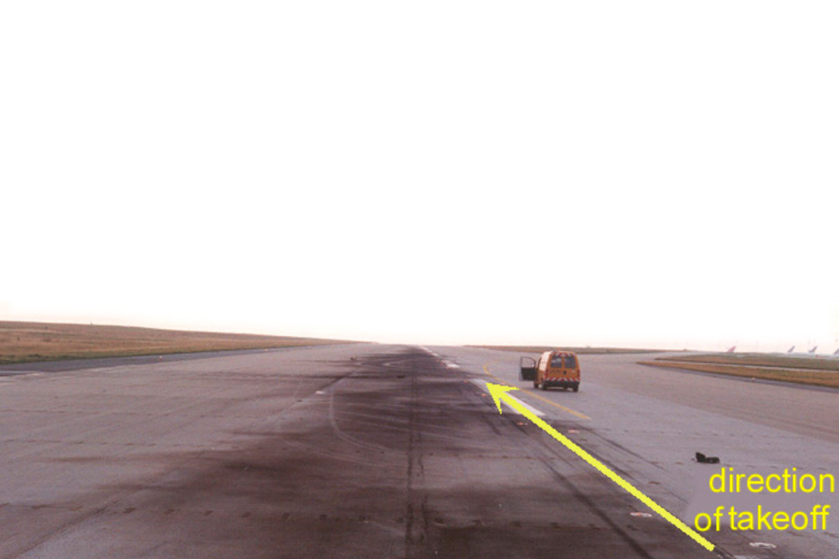 Eine Landebahn, auf der ein orangefarbener Transporter steht. Rechts unten steht in gelber Schrift direction of take off. Ein gelber Pfeil führt schräg durchs Bild